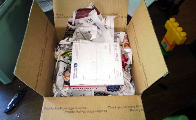 After opening the first box, I discovered a second box safely nestled in a bed of newspaper. (Note: Notice my 3-year-old's creepy Mega Blok figure. Those little pagan-looking totems are all around my house. Creepy!)